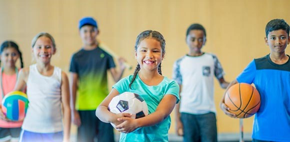 Children of different ages playing sports together.